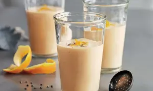 Tre glas med krämig apelsinsmoothie, toppad med rivet apelsinskal och pepparkorn. Ett perfekt smoothie recept för en uppfriskande start.