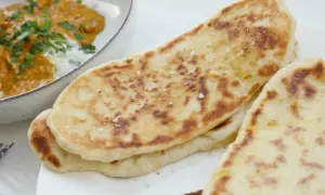 Nybakade, gyllene naanbröd med strössel av flingsalt, perfekta till en krämig curry. Ett enkelt naan recept för hemmabruk.