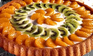 En vacker frukttårta med mandarinklyftor och kiwiskivor som dekoration. Ett perfekt frukttårta recept för sommaren!