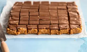 En hel plåt med chokladöverdragna bitar, redo att avnjutas. Ett perfekt snickerskaka recept för fikat.