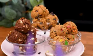 Tre skålar med olika sorters cookie dough recept: choklad med vita chokladknappar, klassisk med chokladknappar och färgglad med godisbitar.