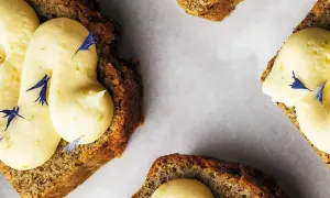 Skivor av saftig sockerkaka med fluffig frosting och blå blomblad. Perfekt att baka med bikarbonat för en luftig kaka.