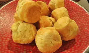 En hög med fluffiga scones i muffinsform på en röd tallrik med prickar. Perfekt för fika!