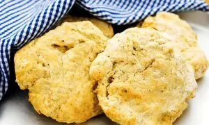 Nyttiga scones, gyllene och fluffiga, vilar under en blåvitrutig handduk. Perfekt för en hälsosam fika.