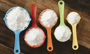 Mätkoppar med mjöl, redo att byta vetemjöl mot glutenfritt för bakning.