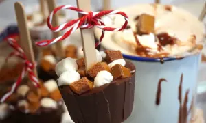 Chokladkoppar med marshmallows och kola, redo att smältas ner i varm choklad. En härlig juldekoration.