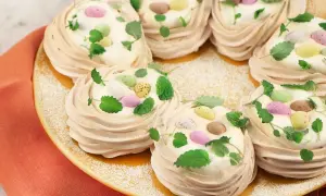 Små marängbottnar fyllda med grädde och dekorerade med färgglada påskägg och mynta. En perfekt pavlova påsk-dessert!