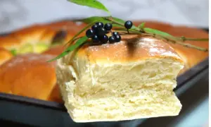 Nybakade, fluffiga tekakor i långpanna, dekorerade med en kvist med svarta bär och gröna blad. Perfekt för fika!