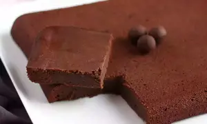 En fudgig chokladkaka, perfekt istället för smör i bakning. Tre chokladkulor ligger på ytan.