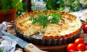 En gyllene paj med en härlig glutenfri pajdeg, fylld med ost och örter. Serveras med färska tomater och lök.