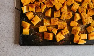 Tärnad pumpa kryddad och redo för ugnen. Ett enkelt steg i ett gott pumpapure recept.