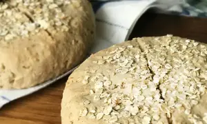 Två hembakta scones med bovetemjöl och havregryn på en kökshandduk.