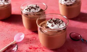Chokladmousse recept: Krämig chokladmousse i glas, toppad med vispad grädde och chokladspån. Perfekt för en lyxig dessert.