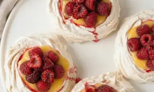 Små marängbottnar fyllda med krämig lemoncurd och toppade med färska hallon och jordgubbar. En härlig pavlova!