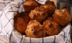 En korg med nybakade scones, perfekt för fika. Sconesdegen har fått en gyllene färg.
