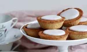 En hög med hembakade mazariner med vit glasyr, redo att avnjutas. Perfekt för ett fika-tillfälle, kanske med ett gott mazariner recept.