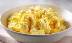En skål med fluffiga, gyllene äggröra, perfekt för en god frukost.