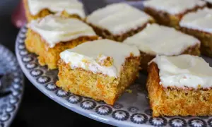 En härlig morotskaka i långpanna, skuren i fyrkantiga bitar med krämig glasyr. Perfekt för fika.