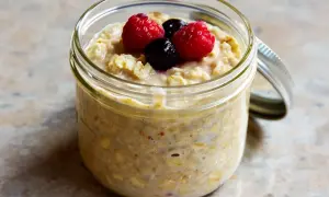 Overnight oats med proteinpulver i burk, toppad med hallon och blåbär. Perfekt för en snabb och näringsrik frukost.