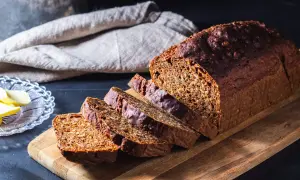 Ett mörkt, saftigt filbröd skuret i skivor, redo att avnjutas med smör.