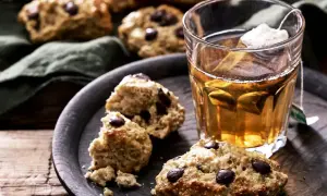 Choklad scones på ett fat med en kopp te. En härlig fika, men tänk på scones kalorier om du vill hålla koll.