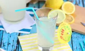 Ett glas hemgjord lemonad med citronskiva och sugrör. Perfekt för ett enkelt lemonad recept en varm sommardag.