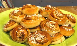 En hög med nybakade kanelbullar, perfekta att baka med mycket mjölk för extra saftighet. Strösslade med pärlsocker.