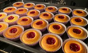 Nybakade hallongrottor med sylt i mitten, redo att avnjutas. Ett perfekt hallongrottor recept för fikat.