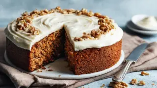 En saftig morotskaka med krämig frosting och valnötter, redo att avnjutas. Perfekt för ett enkelt morotskaka recept.