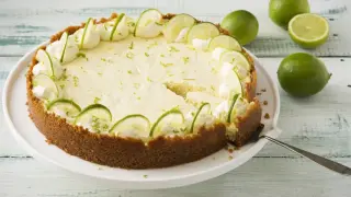 En krämig key lime pie i glas, dekorerad med limeklyftor och vispgrädde.