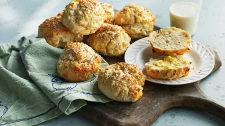 Snabba bullar med sesamfrön, perfekta till frukost eller fika. En halv bulle med smör ligger på en tallrik bredvid.