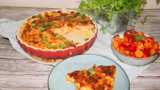 En gyllene paj utan pajdeg, fylld med godsaker och toppad med örter. Serveras med en fräsch sallad av paprika och morötter.
