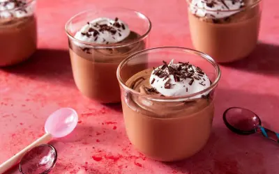 Chokladmousse recept: Krämig chokladmousse i glas, toppad med vispad grädde och chokladspån. Perfekt för en lyxig dessert.