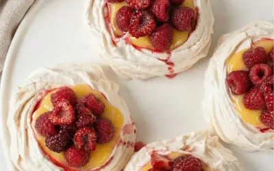 Små marängbottnar fyllda med krämig lemoncurd och toppade med färska hallon och jordgubbar. En härlig pavlova!