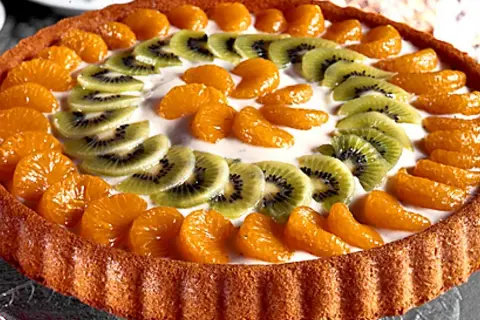 En vacker frukttårta med mandarinklyftor och kiwiskivor som dekoration. Ett perfekt frukttårta recept för sommaren!