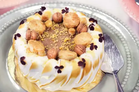 En vacker tårta med maräng och macarons, perfekt för ett speciellt tillfälle. Detta tårta recept ser utsökt ut!