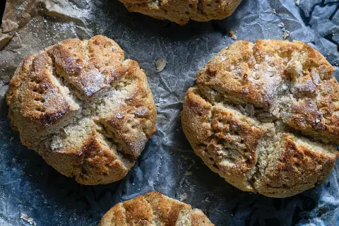 Nybakade scones med kvarg, gyllene och inbjudande, strösslade med lite mjöl. Perfekta för en mysig fika.