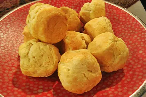 En hög med fluffiga scones i muffinsform på en röd tallrik med prickar. Perfekt för fika!