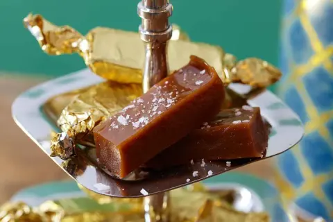 Två bitar salt karamell, perfekt julgodis med lakritssmak, på ett silverfat.