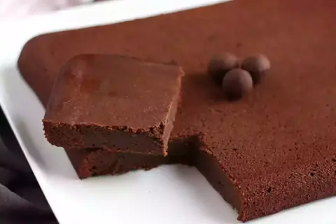 En fudgig chokladkaka, perfekt istället för smör i bakning. Tre chokladkulor ligger på ytan.