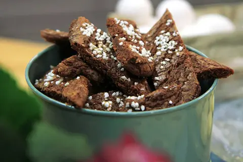 Chokladsnittar recept: Mörka, trekantiga småkakor med pärlsocker i en grön skål. Perfekt för fikat!