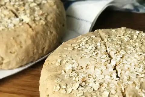 Två hembakta scones med bovetemjöl och havregryn på en kökshandduk.