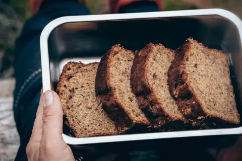 Skivor av saftig banankaka i en metallbehållare, perfekt för utflykten. Ett enkelt banankaka recept som passar alla.