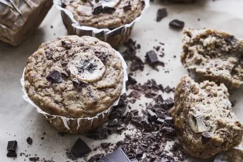 Nyttiga bananmuffins med chokladbitar och bananskivor, perfekta för fika.