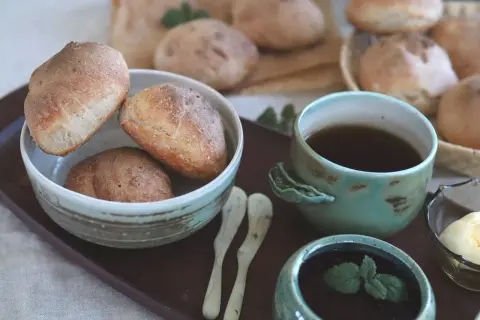 Nybakade bullar, resultatet av noggrann knådning, serveras med te och smör.