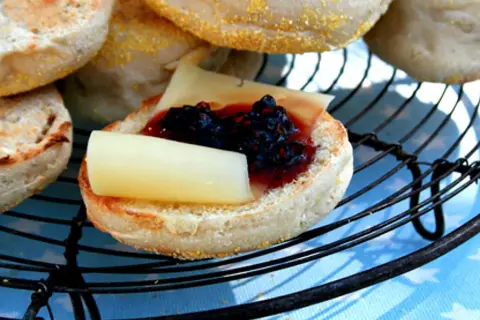 En engelsk muffin med ost och sylt, perfekt för ett snabbt frukostrecept.