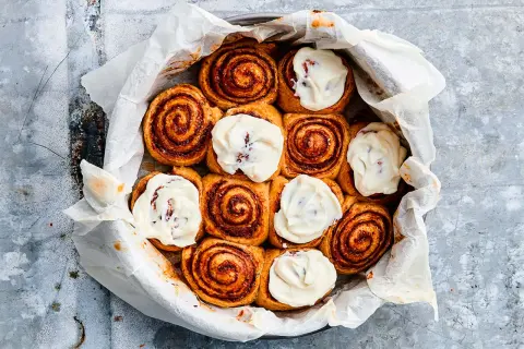 Nybakade kanelbullar med krämig glasyr, redo att jäsa deg till perfektion.