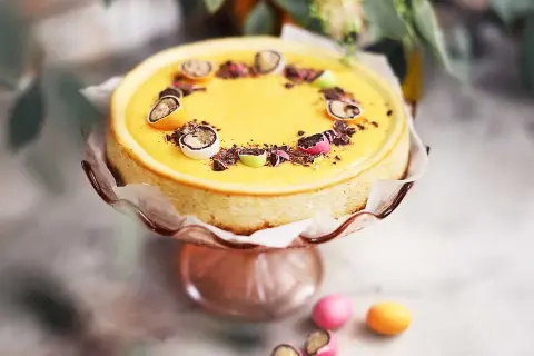 En gul cheesecake med påskpynt, choklad och små ägg. En perfekt cheesecake påsk-dessert.
