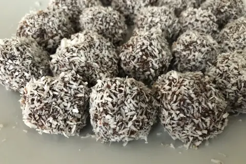 En hög med chokladbollar, perfekta för ett enkelt chokladbollar recept. De är rullade i kokosflingor.