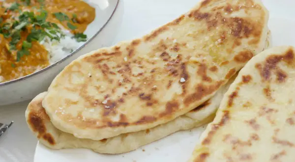 Nybakade, gyllene naanbröd med strössel av flingsalt, perfekta till en krämig curry. Ett enkelt naan recept för hemmabruk.